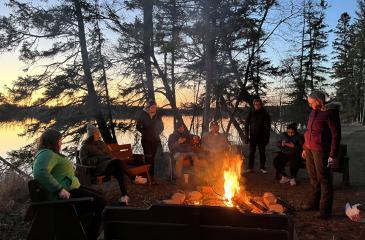Student around a campfire at the Apri 2024 Itasca Experience
